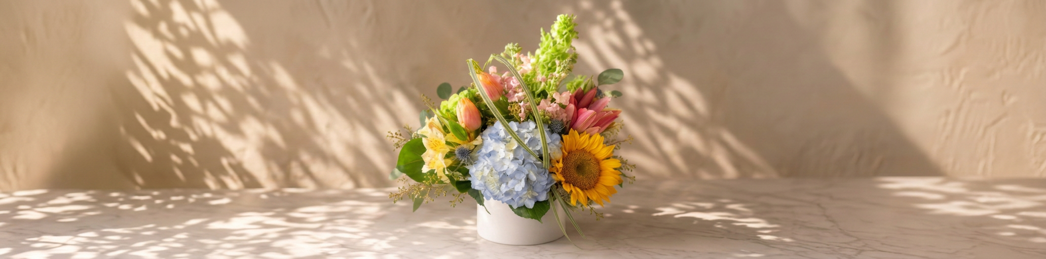 Colorful seasonal flower arrangement with sunflowers, hydrangea and tulips